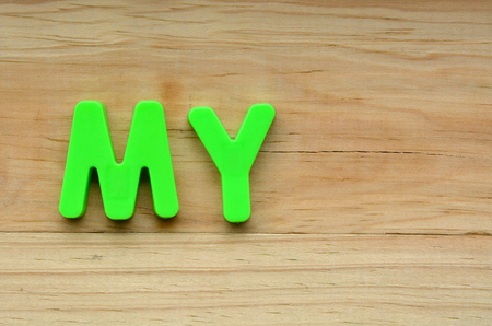 Flat lay of the word My on a wooden background.  Identity concept with copy space for textの写真素材