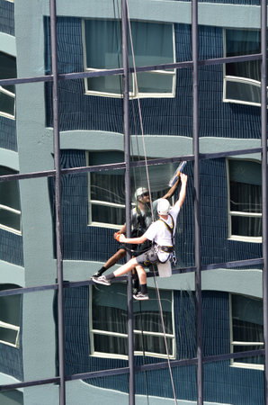 AUCKLAND - MAR 02 2016:Window cleaner works on high rise building.Window cleaning is considered one of the most dangerous job in the world.Several window cleaners die each year and many are injuredのeditorial素材