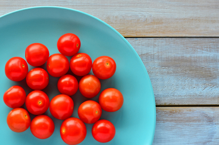Flat lay view of a Cherry tomatoes on a turquoise plate. Food background and texture. Copy spaceの写真素材