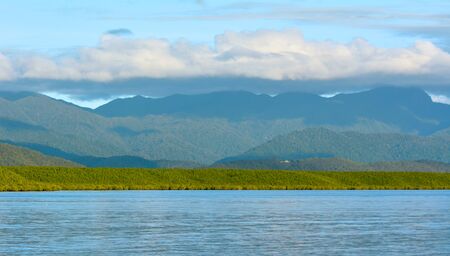 Landscape of rainforest mountains meets the Pacific ocean in the tropical north of  Queensland,...