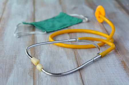 Doctors stethoscope and surgical mask on a wooden table. Healthcare concept copy spaceの写真素材