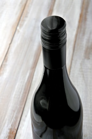 Red wine bottle on a wooden table background. Vertical copy spaceの写真素材