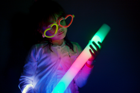 Little girl (age 6) plays with colorful lights in the darkの写真素材
