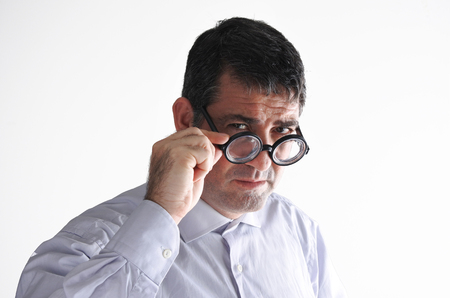Middle aged man (40-50) holds is glasses and looks at the camera head and shoulders shot. Men lifestyle concept. copy spaceの写真素材