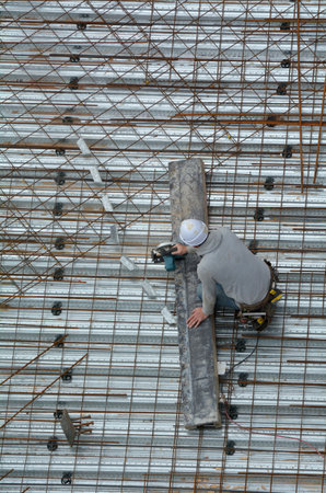 Aerial view of unrecognized roofer construction worker works in a construction site. Building...
