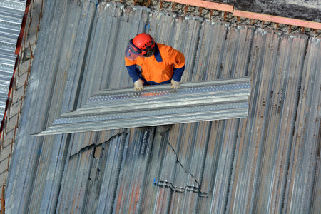 Aerial view of unrecognized roofer construction worker in a construction site. Building development concept with copy spaceのeditorial素材
