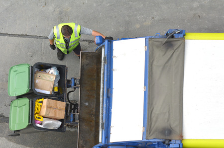 Aerial view of unrecognized Garbage man loading garbage truck. Rubbish and recycling concept with copy spaceの写真素材