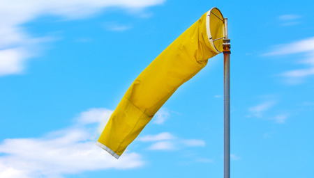 A yellow windsock used at airports to indicate the direction and strength of the wind to pilots.の写真素材
