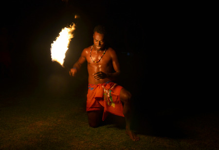 Fijian man holds a tourch during a fire dance at nigh in Fiji. Real people copy spaceの写真素材