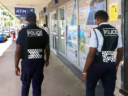 LAUTOKA, FIJI -  DEC 30 2016:Fijian police officers patrolling in the main street. The Fiji Police Force annual statistics reveal an 18% increase in crime cases in 2015.のeditorial素材