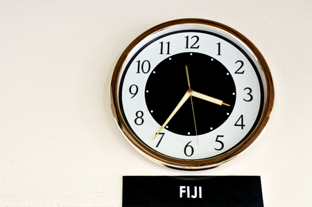 A clock on the wall show Fiji Time in hotel. Travel concept.