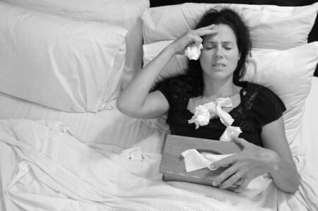 Sick woman (age 30) lay in bed. Medical concept. Real people. copy space (BW)の写真素材