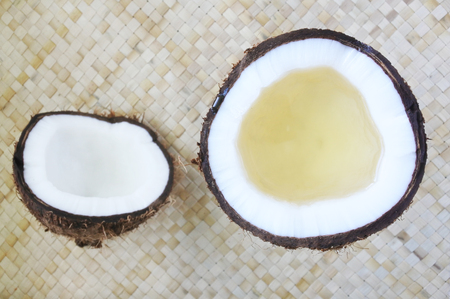 Flat lay of open coconut palm fruit with coconut oil in it. Coconut oil is one of the major uses for the fruit and is seen as having a variety of applications in beauty, health, and cooking.の写真素材