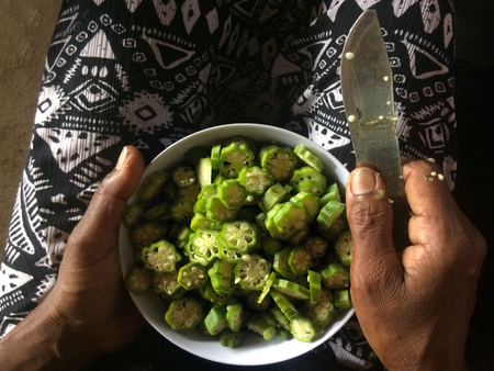 Indo-Fijian woman hands slicing Okra with knife into a bowl.Food backgroundの写真素材