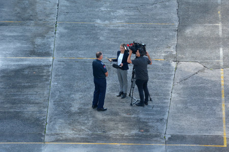 Auckland, New Zealand - May 17 2017: Aerial view of a cameraman and woman reporter during a news interview. The work of photojournalism must be timely and relevant to contemporary news stories.のeditorial素材