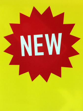 New product item sign in bright yellow, red and white colours. Business background. Copy spaceの写真素材