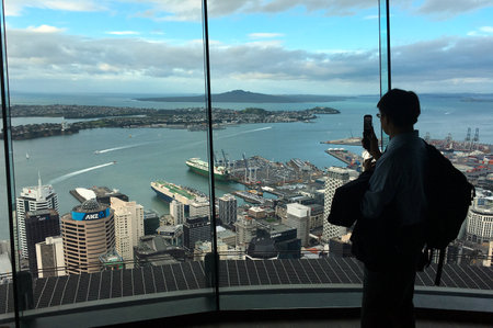 AUCKLAND - AUG 03 2017:Visitor take photo with his mobile phone from Auckland's Sky Tower observation deck. In 2016 Auckland hosted a record total of 2.217 million international visitors.のeditorial素材