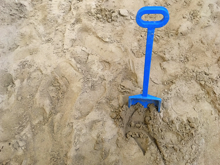 A blue toy spade in a sand. Summer holiday concept. Copy spaceの写真素材
