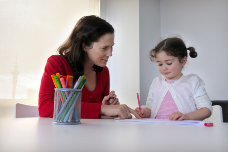 Mother (age 30) and daughter child (age 03) draw and paint together. Togetherness concept. Real people. Copy spaceの写真素材