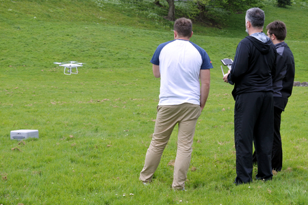 Unrecognizable men flying a drone in the park. Ethical concerns and UAV-related accidents have driven nations to regulate the use of UAVs.の写真素材