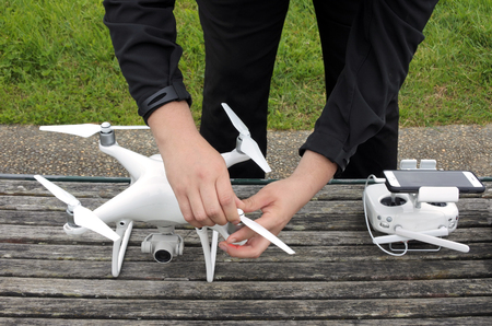 Unrecognizable person prepares a drone for a flight. Real people. Copy space