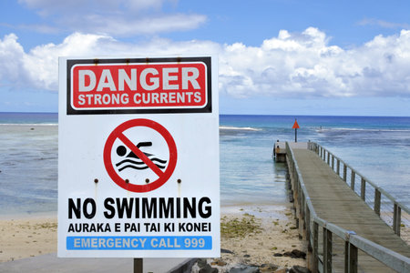 RAROTONGA - JAN 28 2018: Danger Strong Currents - No Swimming sign. The most dangerous water hazard in Rarotonga in the Cook Islands, are the channels linking the lagoon into the oceanのeditorial素材