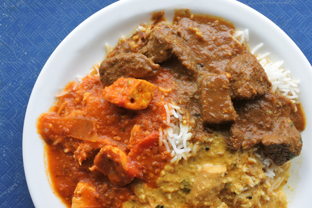 Above view of three types on Indian curries (Rogen Josh, Madras, Tikka Masala) served on a plate. Indian food backgrounds and cuisine textures.Copy spaceの写真素材