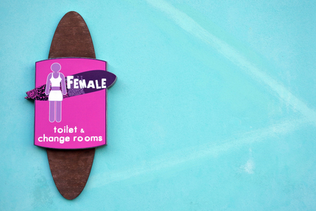 Toilet sign for females in the shape of a surf board at the entrance to a public toiletの写真素材