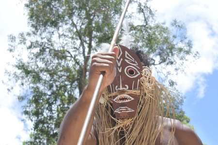 Unrecognizable Torres Strait Islander man dancing traditional dance in Torres Strait Islands near...