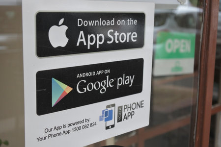 Melbourne, Australia - April 01, 2019: App Store and Google Play stickers on a shop door, a digital distribution platforms for Apple and Android operating systems allowing users to browse and download applications.のeditorial素材