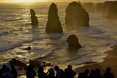 Silhouette of Tourists looking at the Twelve Apostles Great Ocean Road in Victoria Australiaの写真素材