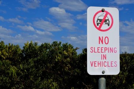 A road sign reads: No sleeping in vehicles.