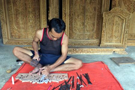 Indonesia man wood carver carving sculptures in Mas, Bali Indonesia.の写真素材