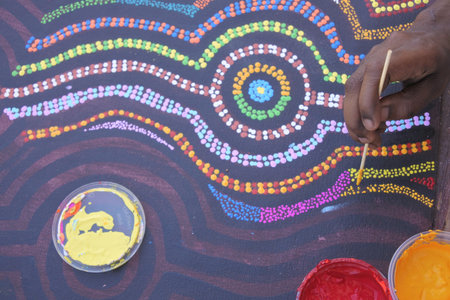 DERBY, WA - SEP 10 2019:Aboriginal artist dot painting.Before Indigenous Australian art was ever put onto canvas the Aboriginal people would smooth over the soil to draw sacred ceremony designs.のeditorial素材