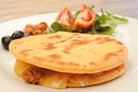 Traditional Moroccan bread served on a white plate with fresh vegetables, tuna and black olives. Food background. No people. Copy spaceの写真素材