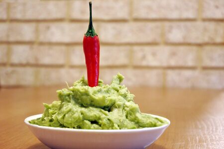 Guacamole Avocado-based dip served with Hot Chili Pepper on Top .Guacamole is a Latin American cuisine, spread, condiment and salad ingredient. No people. Copy spaceの写真素材