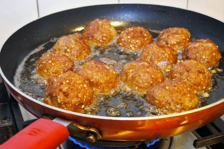 Fresh Kibbeh fired in a frying pan. Kibbeh is  a Levantine dish made of bulgur, minced onions, and...