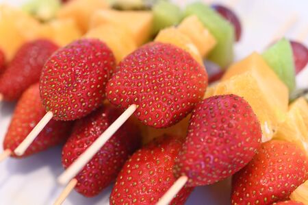 Colorful rainbow colors fruit kebab sticks close up view served on a rainbow theme birthday party.の写真素材