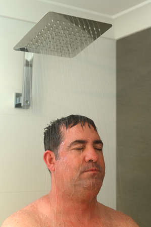 Mature adult man (age 40-50) having a shower.