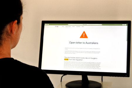 Australian woman reading warnings on Google website. Google has been slammed in a new open letter for its threats over a plan that would require it to pay for news.のeditorial素材