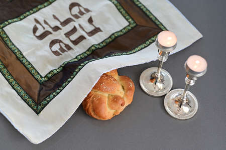 Challah (special Jewish bread) and two lit candles on Sabbath eve Jewish Holiday (Judaism's day of...