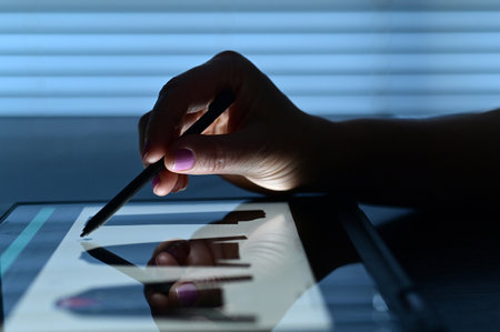 Woman hand using an electronic pencil shopping fashion clothing online on a tablet touch screen.