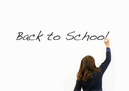 Primary schoolgirl writing: "Back to school" on a whiteboard.Education concept. Real people. Copy spaceの写真素材