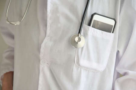 Physician doctor carrying stethoscope and mobile phone.Concept photo of online medical health care...