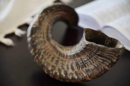 Close up of Shofar (rams horn) Tallit and Jewish prayer book on a wooden table.の写真素材