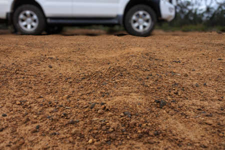 Low angle view of a 4WD off road vehicle driving on a very corrugate dirt road in Western Australia outback.の写真素材
