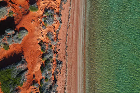 Aerial drone view of coastal sea shore red cliffs and turquoise water at Peron Peninsula in Shark...