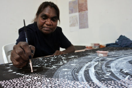 KUNUNURRA, WA - AUG 09 2022:Aboriginal artist dot painting.Before Indigenous Australian art was ever...