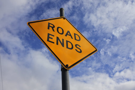 Road ends traffic sign under dramatic blue sky with clouds.の写真素材