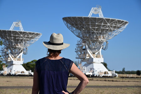 NARRABI, NSW - MAR 03 2023:Australian woman looking at the Telescope Compact Array near Narrabri NSW, that observe star formation, the late stages of stars lives, supernovae and magnetic fields.のeditorial素材